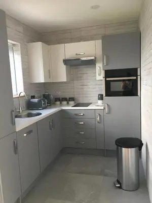 a kitchen with white cabinets and a white refrigerator at Blue Watch in Lochaline