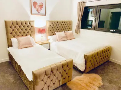 a bedroom with two beds and a large window at Glasgow City Centre - The PENTHOUSE with RiverViews - (Duplex, 3 Bedrooms, 3 Bathrooms, 2 Living rooms/Kitchen, Private SKY Terrace, 2 Parkings, Top Floor, Huge - 2100 sq ft, SECC HYDRO) in Glasgow