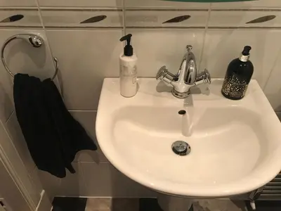 a bathroom sink with two soap bottles on it at The Neuk in Uphall