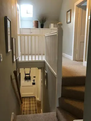 a staircase in a home with a white stair case at Chefs cottage in Kenmore