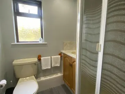 a bathroom with a toilet and a sink and a window at Puffin - Kerrera in Lerags