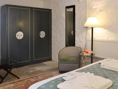 a bedroom with a bed and a chair and cabinets at The Calving Shed in Neilston