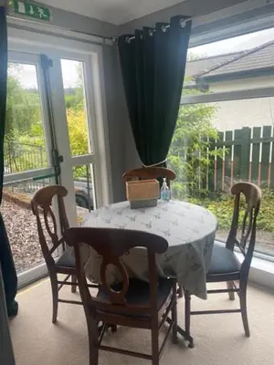 a table and chairs with a vase on top of it at Sir Andrew Murray House in Strathyre