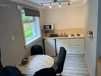 a kitchen with a table and chairs and a table and a table and a kitchen at Sir Andrew Murray House in Strathyre