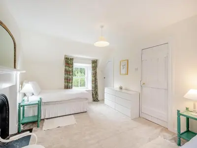 a white bedroom with a bed and a window at Inverglen Farm in Strachur