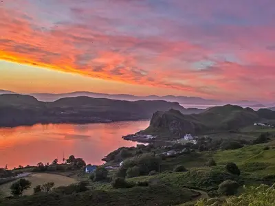 a sunset over a body of water with mountains at Puffin - Bach in Lerags