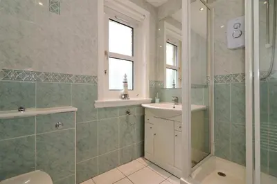 a bathroom with a shower and a sink and a toilet at Signature - Shawburn House in Hamilton