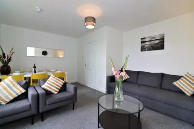 a living room with two couches and a table at Signature - Belhaven House in Hamilton