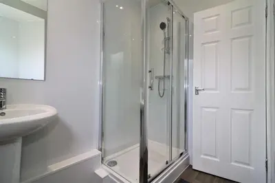 a white bathroom with a shower and a sink at Signature - Belhaven House in Hamilton