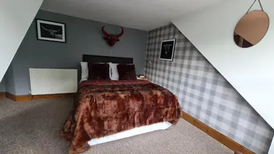 a bedroom with a large bed in a attic at The Coylet Inn by Loch Eck in Dunoon