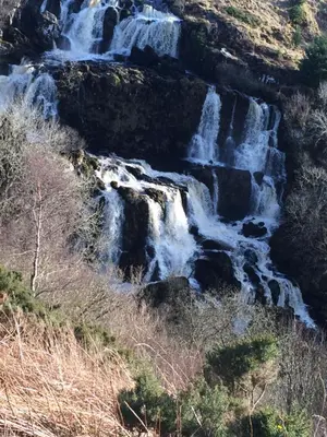 a waterfall on the side of a mountain at Dunroamin in Drymen