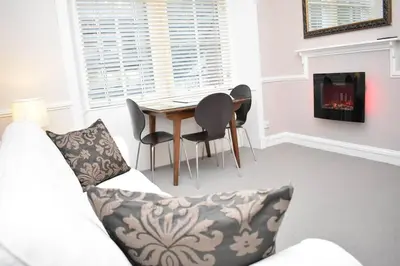 a living room with a table and chairs and a fireplace at West Port - 2BR in the heart of the old town just off the Grassmarket in Edinburgh