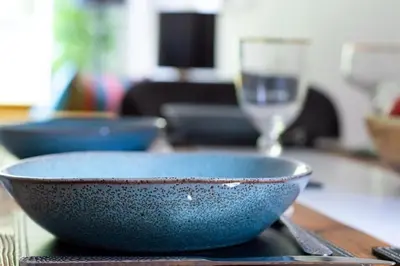 a blue bowl and a glass on a table at Castle View Luxury 1 Bed Apartment in Edinburgh