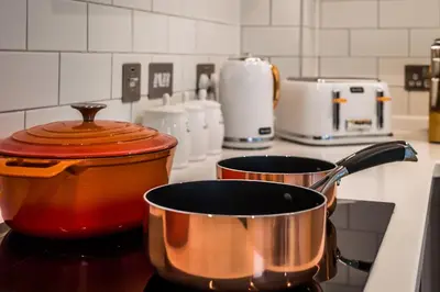 two pots and pans sitting on a stove in a kitchen at Castle View Luxury 1 Bed Apartment in Edinburgh