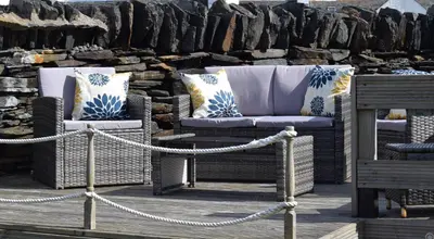 a group of wicker chairs sitting on a dock at Number 10, Isle of Luing in Cullipool