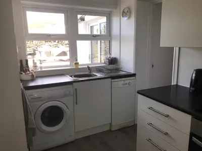a kitchen with a washing machine and a sink at Number 10, Isle of Luing in Cullipool