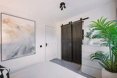 a bedroom with a black door and a plant at Emirates ApartHOUSE in Glasgow