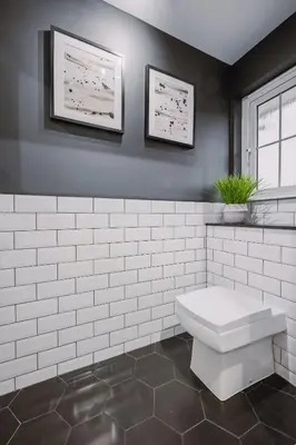 a bathroom with a white toilet and two pictures on the wall at Emirates ApartHOUSE in Glasgow