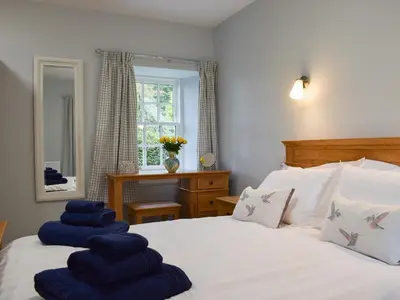 a bedroom with a bed with blue towels on it at The Old Stables At Westerton in Crieff