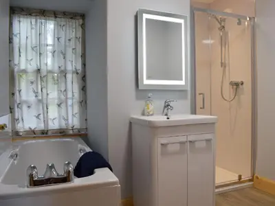 a bathroom with a tub and a sink and a shower at The Old Stables At Westerton in Crieff