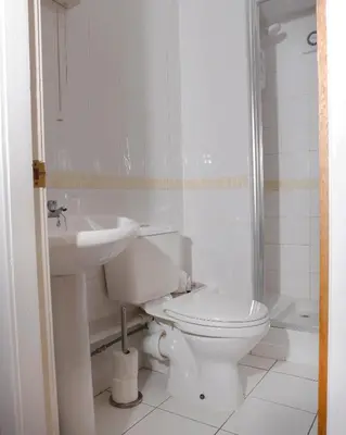 a white bathroom with a toilet and a sink at The Dunning Hotel in Perth
