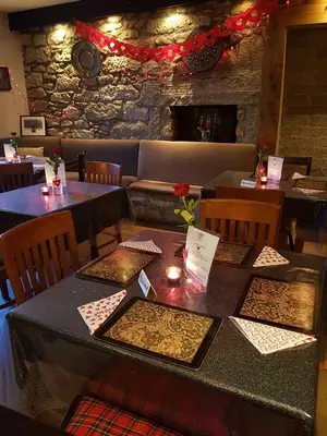 a restaurant with tables and chairs with candles on them at The Dunning Hotel in Perth