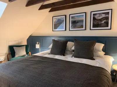 a bedroom with a large bed with three pictures on the wall at The Balerno Inn in Edinburgh