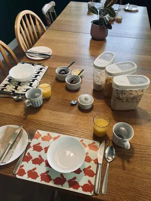 a wooden table with a plate and utensils on it at Altquhur Byre in Drymen