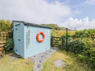a blue outhouse with an orange life preserver on it at Grebe Cottage in Oban