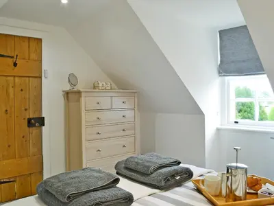a bedroom with a bed with a dresser and towels at Altbeg in Brodick