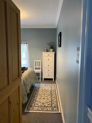 a bedroom with a bed and a dresser and a window at Holly Cottage in Glencoe