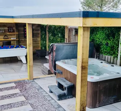 a jacuzzi tub in the backyard of a house at Hazells Lodge Farm Stay Sleeps 2 Undercover Hottub and Pool Table in Galston