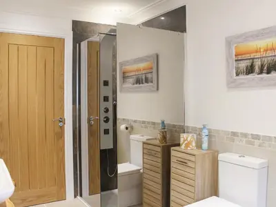 a bathroom with a shower and a toilet and a sink at Rhunahaorine Cottage in Gortinanane