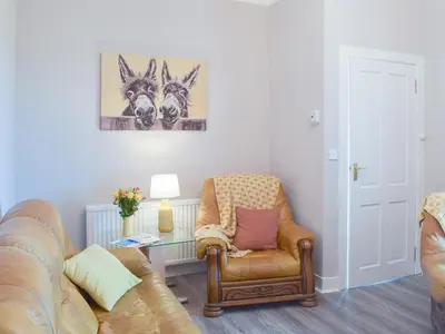 a living room with a couch and a chair at Ardlochan Cottage in Maidens