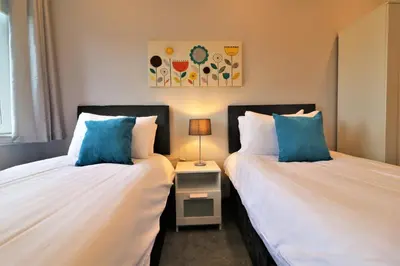 two beds sitting next to each other in a bedroom at Signature - Greenlees Clubhouse 3 Bed in Cambuslang