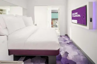 a white bed in a room with purple flooring at YOTEL Glasgow in Glasgow
