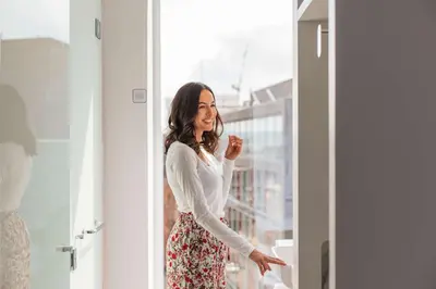 a woman standing in front of a window at YOTEL Glasgow in Glasgow