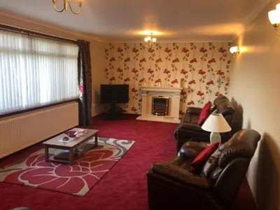 a living room with two chairs and a fireplace at Inveroran in Campbeltown