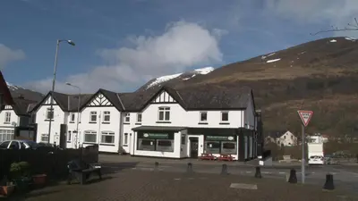 a large white building in front of a mountain at Highland Getaway in Kinlochleven
