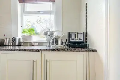 a kitchen counter with a microwave and a window at Glasgow Emo in Glasgow