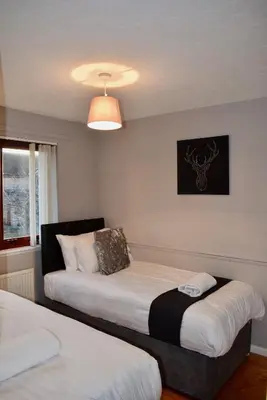a room with two beds and a light at Kelpies Serviced Apartments Hamilton- 2 Bedrooms in Falkirk