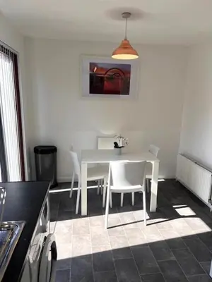 a kitchen with a white table and white chairs at Kelpies Serviced Apartments Hamilton- 2 Bedrooms in Falkirk