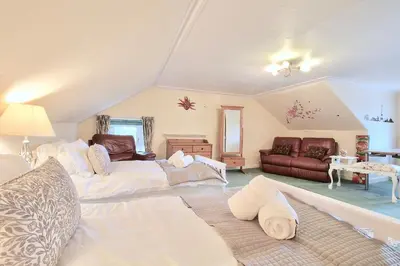 a living room with two beds and a couch at Duneira House in Helensburgh