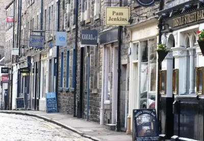 a street with a bunch of signs in front of buildings at Thistle Street Apartment at Heart of the City Centre in Edinburgh