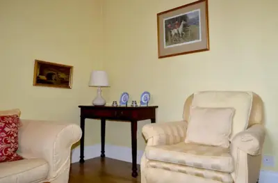 a living room with two chairs and a table at Thistle Street Apartment at Heart of the City Centre in Edinburgh