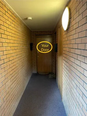 a sign that says your door in a brick hallway at Cozy Nights - Cambuslang 1/64 in Glasgow