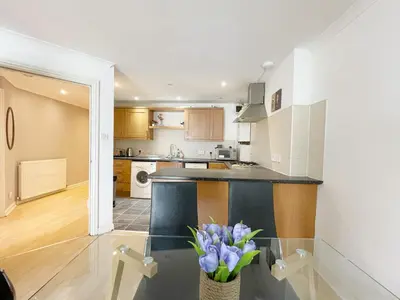 a kitchen with a counter and a vase of purple flowers at Cozy Nights - Cambuslang 1/64 in Glasgow