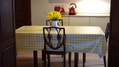 a table with a yellow and white checkered table cloth at Kinneil Self Catering in Lamlash