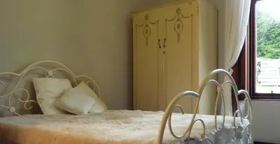 a bedroom with a bed with a headboard and a window at Kinneil Self Catering in Lamlash