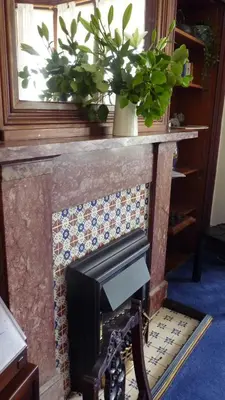 a fireplace with a potted plant on top of it at Kinneil Self Catering in Lamlash